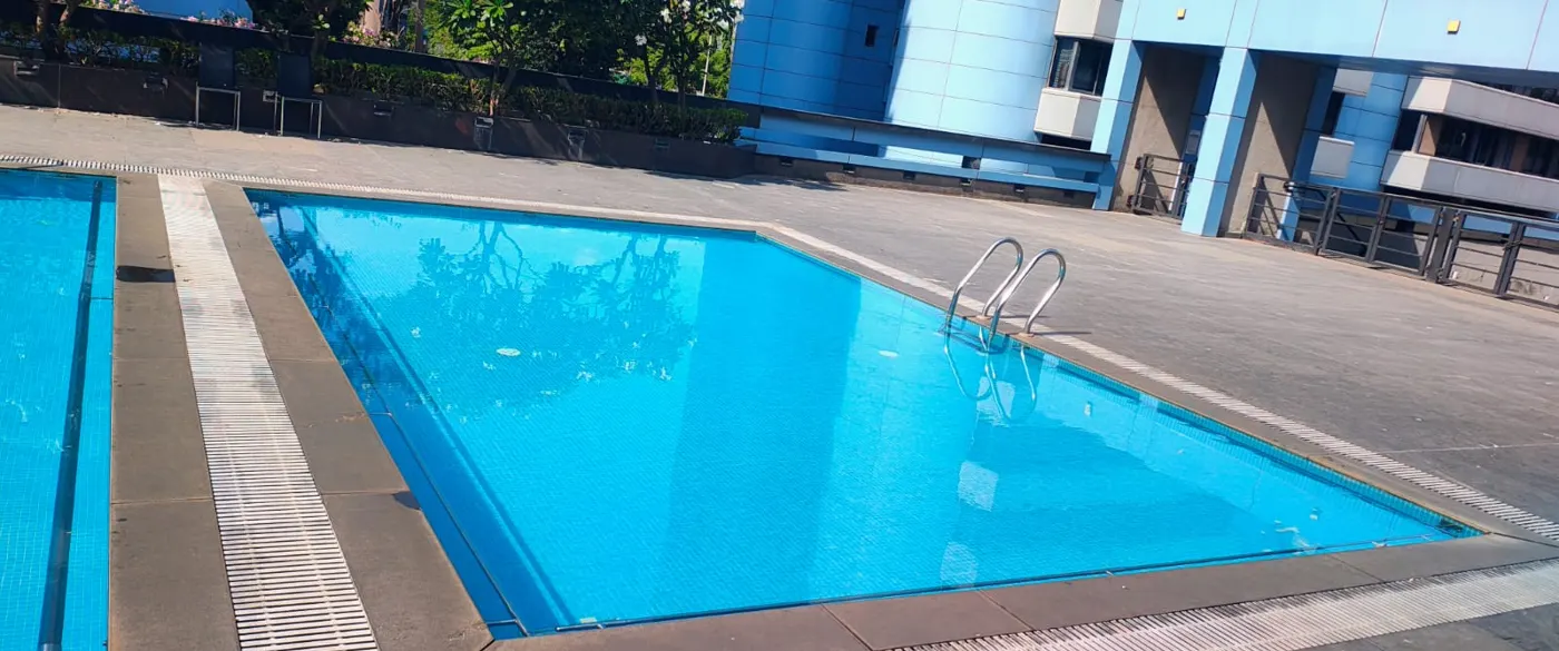 Rectangular overflow swimming pool with stainless steel ladder and deck grating